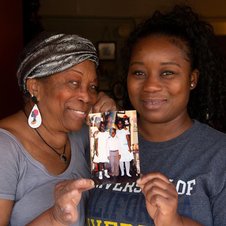 Deidre Reyes, 46, holds a family photo with her mother, Sally Reyes, 71, during a visit to her home in Los Angeles on March 24, 2021. (UCR/Stan Lim)